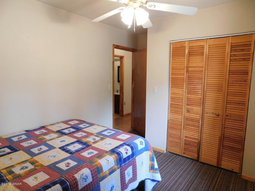 2136 Cottontail Road Overgaard, AZ 85933 - Photo 10 of 23 a bedroom with a bed and wooden floor