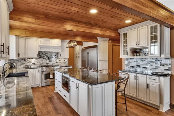 a kitchen with stainless steel appliances granite countertop a stove and a sink