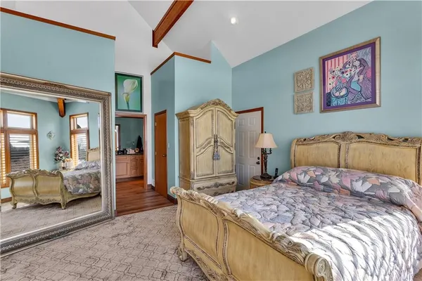 a bedroom with a large bed and a large mirror