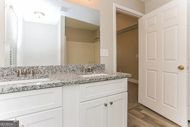 a bathroom with a granite countertop sink and a mirror