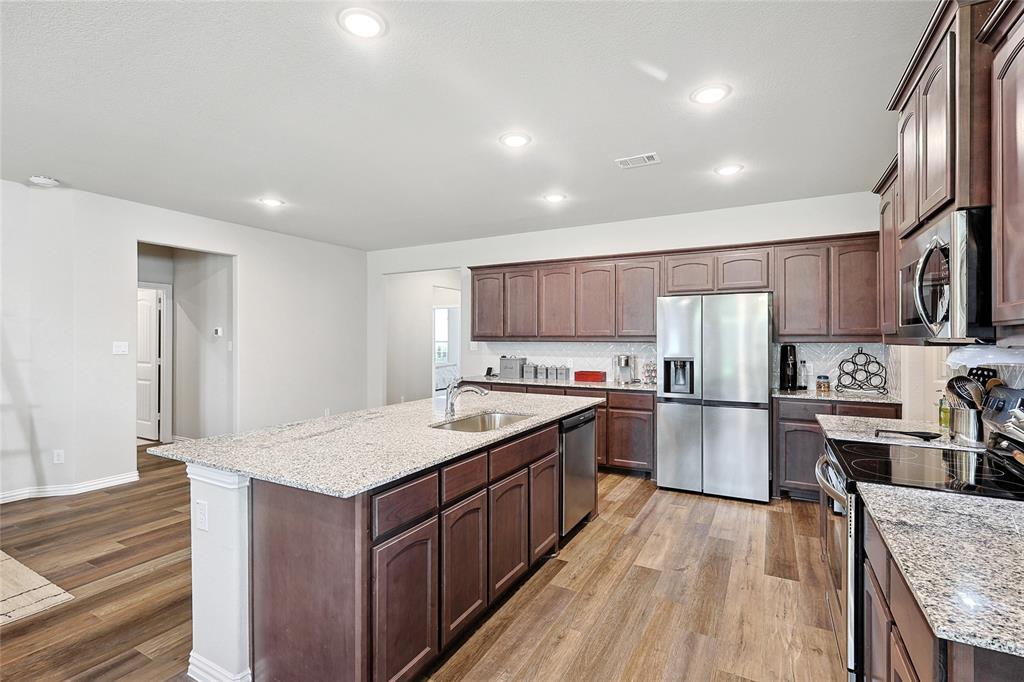 808 Feather Edge Drive Springtown, TX 76082 - Photo 16 of 40 a kitchen with refrigerator cabinets and wooden floor