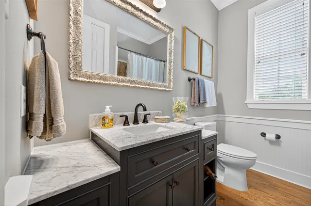 a bathroom with a granite countertop sink a toilet and a mirror