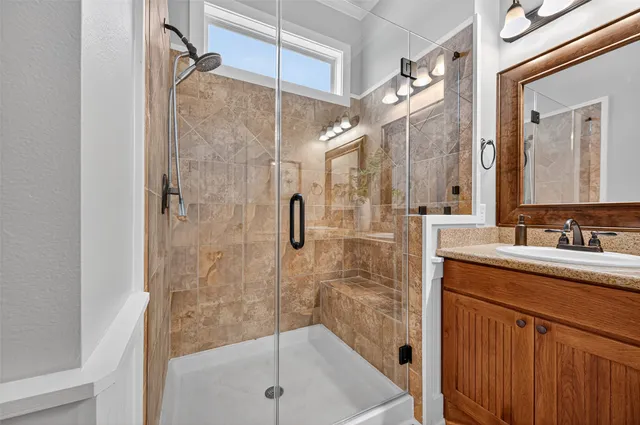 a bathroom with a shower sink and mirror