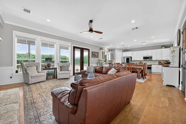 a living room with furniture kitchen area and a large window