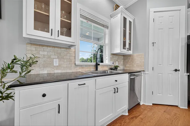 a kitchen with granite countertop white cabinets and white stainless steel appliances