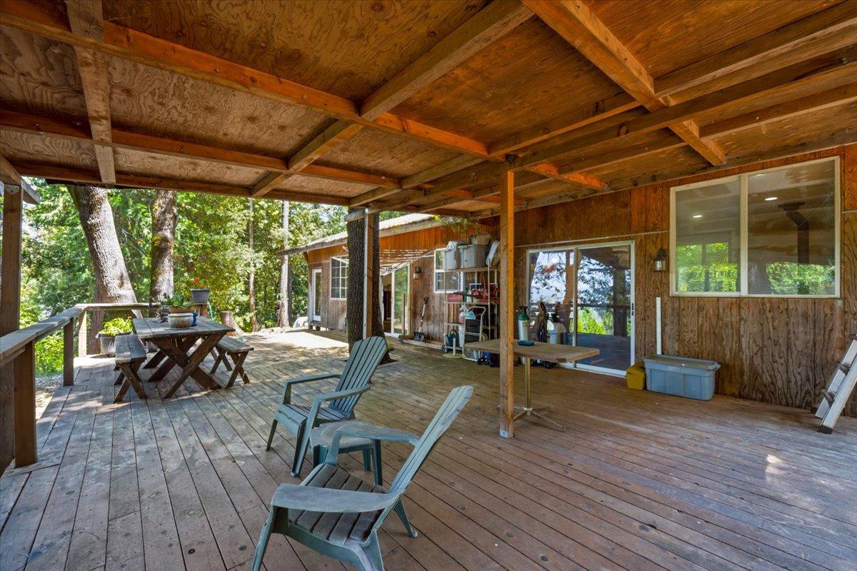 19643 Sages Road Nevada City, CA 95959 - Photo 19 of 39 a view of a patio with table and chairs potted plants with wooden floor and fence