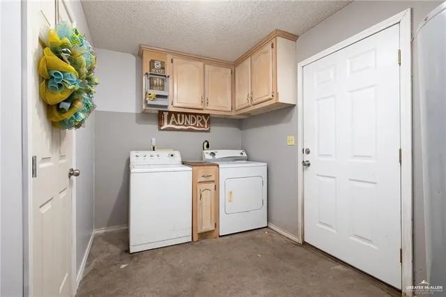 a utility room with cabinets washer and dryer