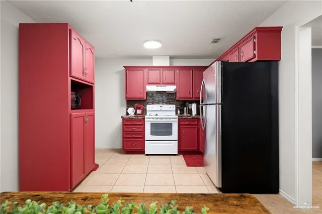 a kitchen with stainless steel appliances granite countertop a refrigerator and a stove top oven
