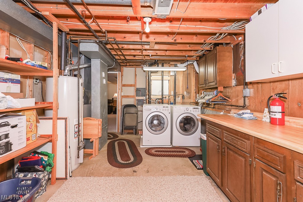 1826 Sandgate Road Madison, OH 44057 - Photo 25 of 29 Laundry area featuring water heater, independent washer and dryer, and cabinets