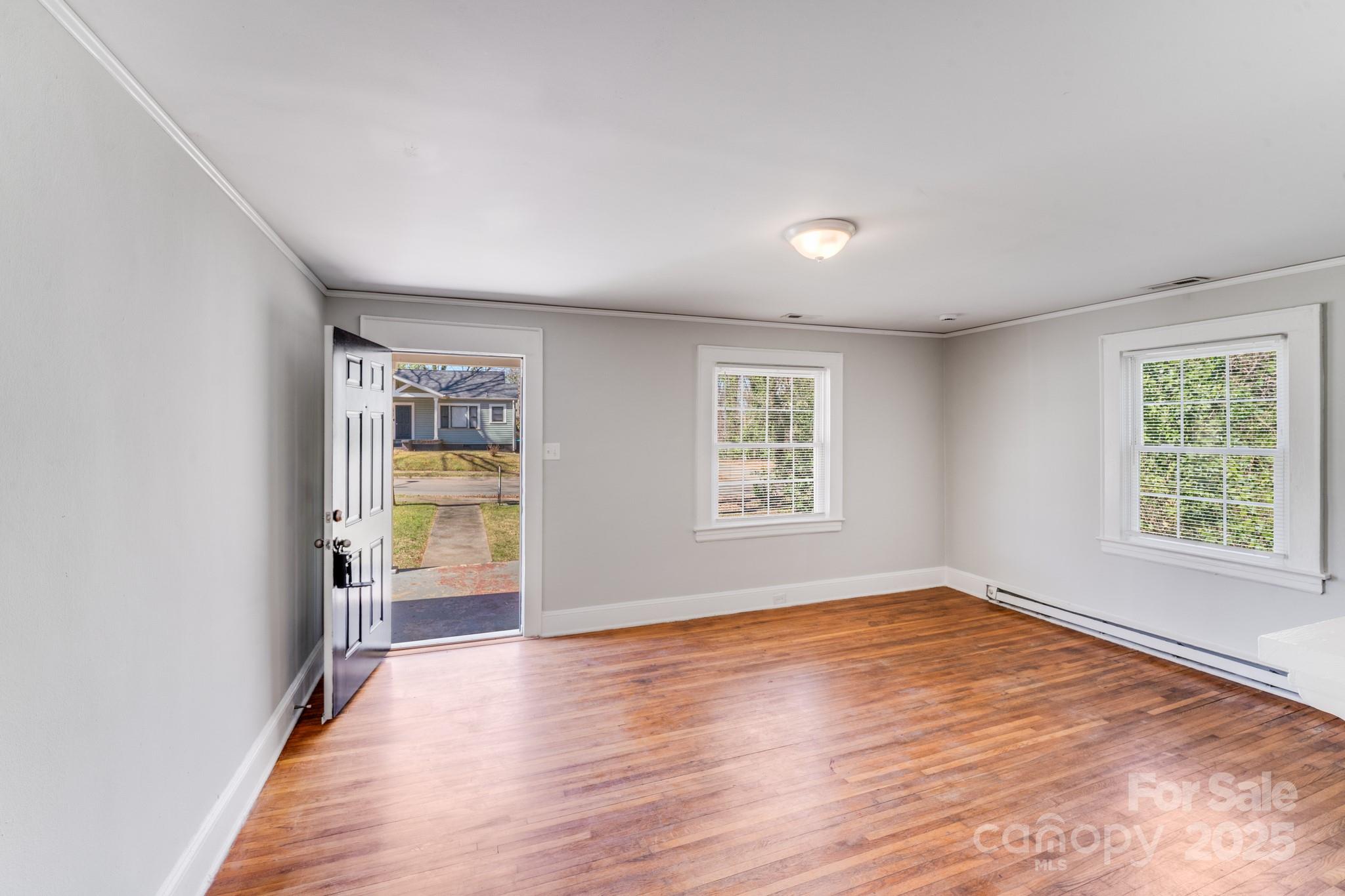 3138 Morson Street Charlotte, NC 28208 - Photo 2 of 21 wooden floor in an empty room with a window