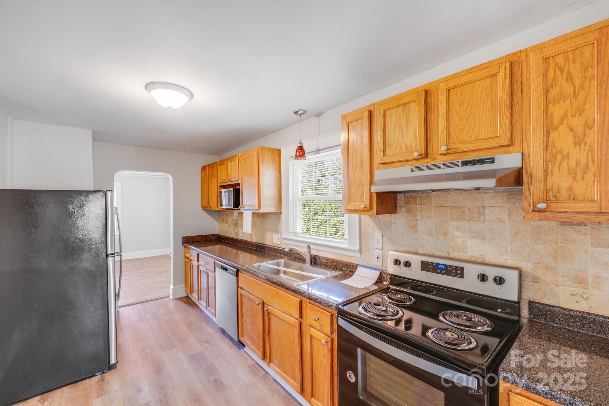 3138 Morson Street Charlotte, NC 28208 - Photo 4 of 21 a kitchen with stainless steel appliances granite countertop a stove a refrigerator and a sink