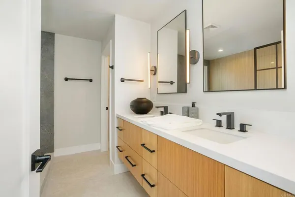 a bathroom with a double vanity sink a mirror and shower
