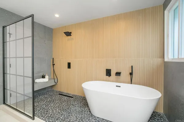 a white bath tub sitting next to a white wall