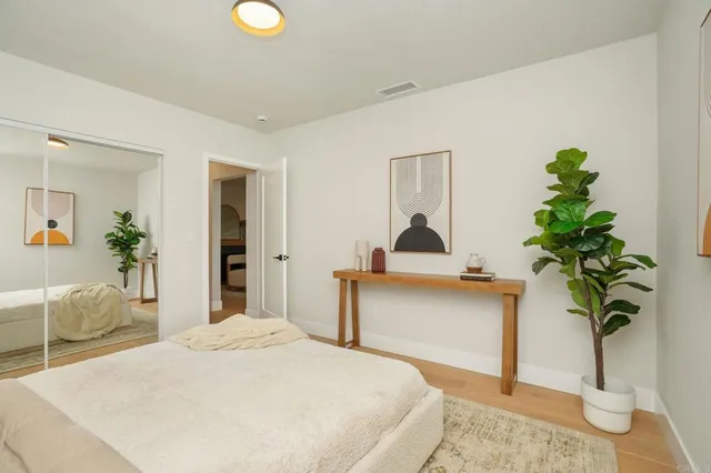 a bedroom with a bed and a potted plant