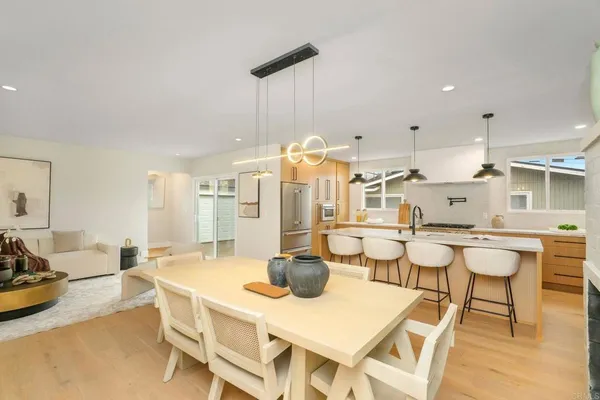 a dining room with stainless steel appliances a table and chairs