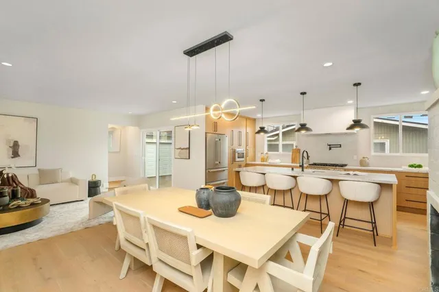 a dining room with stainless steel appliances a table and chairs