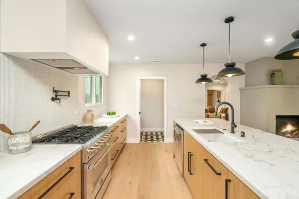 a large kitchen with kitchen island granite countertop a sink stainless steel appliances and cabinets
