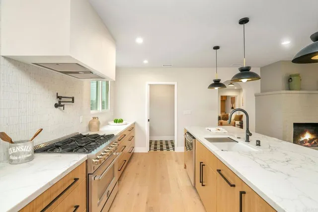 a large kitchen with kitchen island granite countertop a sink stainless steel appliances and cabinets