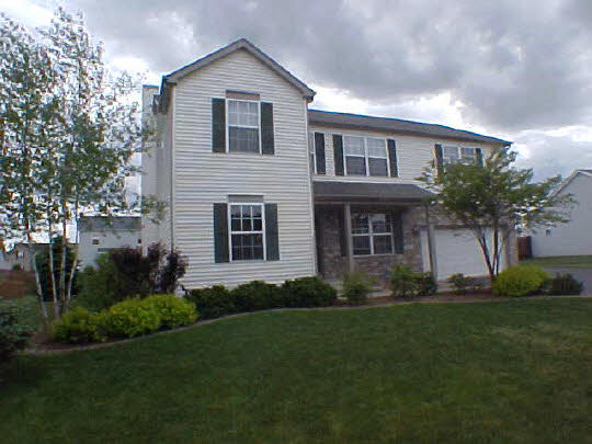 a front view of a house with a garden and yard