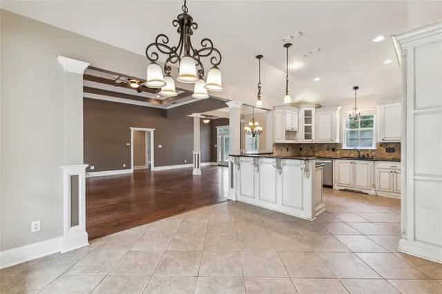 a kitchen with stainless steel appliances granite countertop white cabinets and a stove