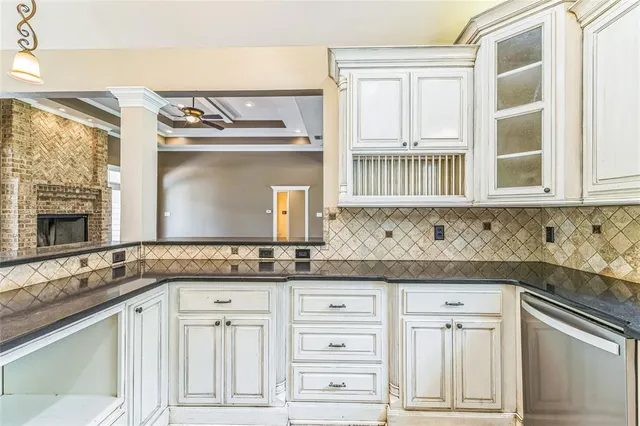a kitchen with granite countertop white cabinets and a stove