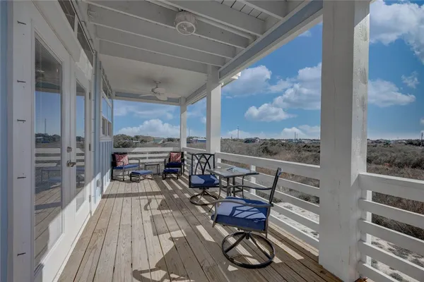 a view of a balcony with chairs and wooden floor