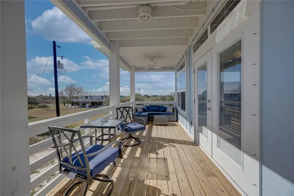 a view of a balcony with chairs and wooden floor