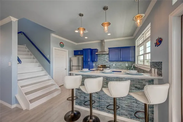 a kitchen with a dining table chairs sink and cabinets