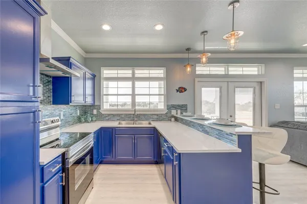 a kitchen with granite countertop a sink stove and cabinets