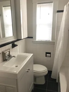 a bathroom with a sink a toilet and a window