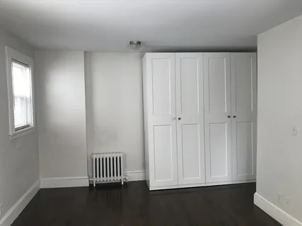 a view of a bedroom with wooden floor