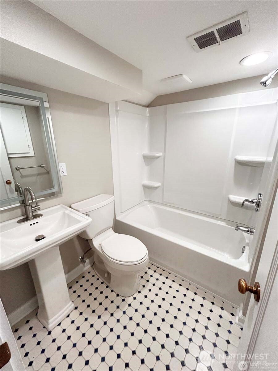 10826 Meadow Road Southwest Lakewood, WA 98499 - Photo 29 of 40 a bathroom with a bathtub a sink a toilet and a mirror
