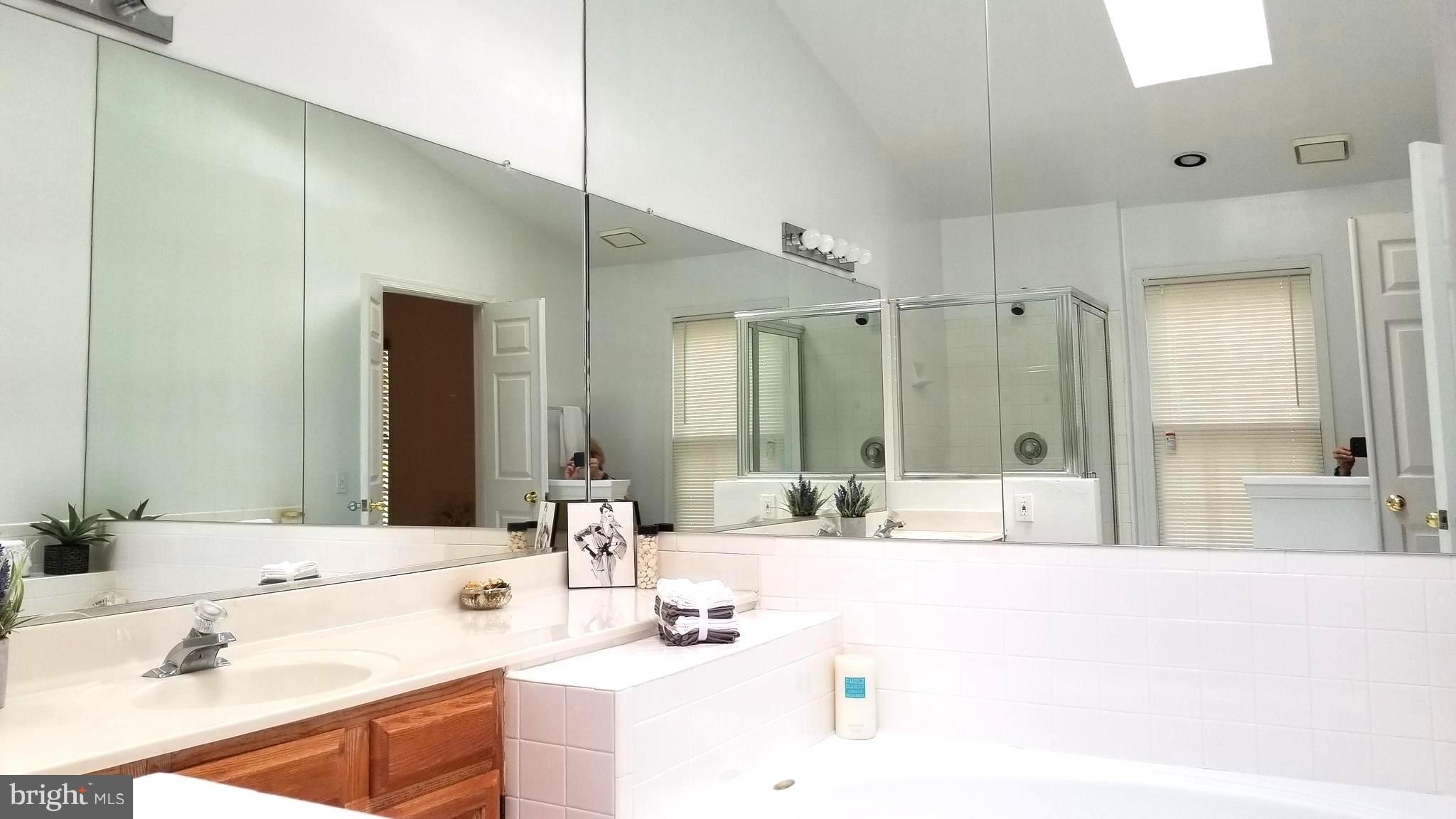 10955 Rocky Mt Way Silver Spring, MD 20902 - Photo 17 of 30 a bathroom with a tub sink and mirror