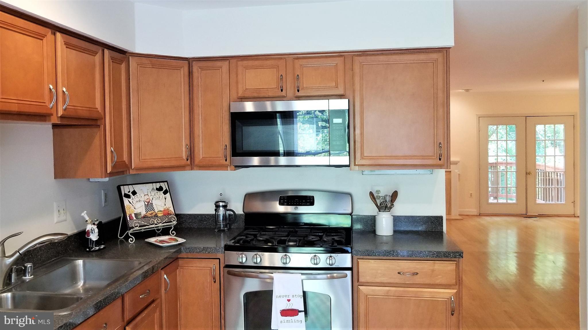 10955 Rocky Mt Way Silver Spring, MD 20902 - Photo 4 of 30 a kitchen with granite countertop a sink stove and cabinets
