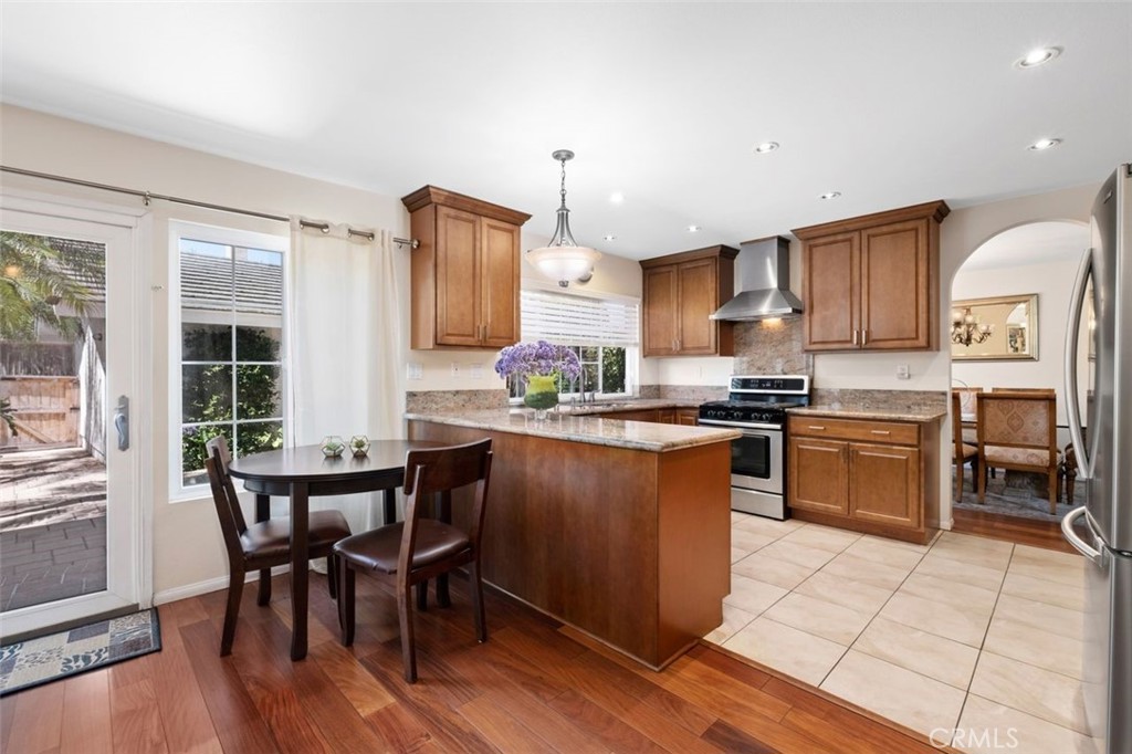 13 West Yale Loop, Unit 2 Irvine, CA 92604 - Photo 18 of 39 a kitchen with stainless steel appliances granite countertop a stove top oven a sink dishwasher a dining table and chairs with wooden floor