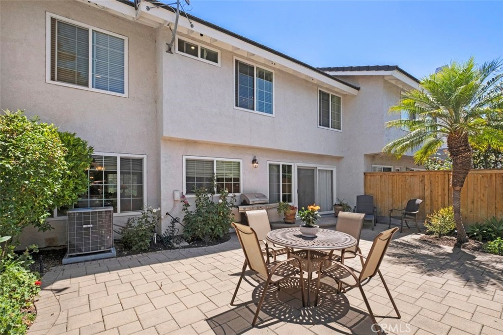 13 West Yale Loop, Unit 2 Irvine, CA 92604 - Photo 36 of 39 a view of a patio with table and chairs potted plants and palm trees
