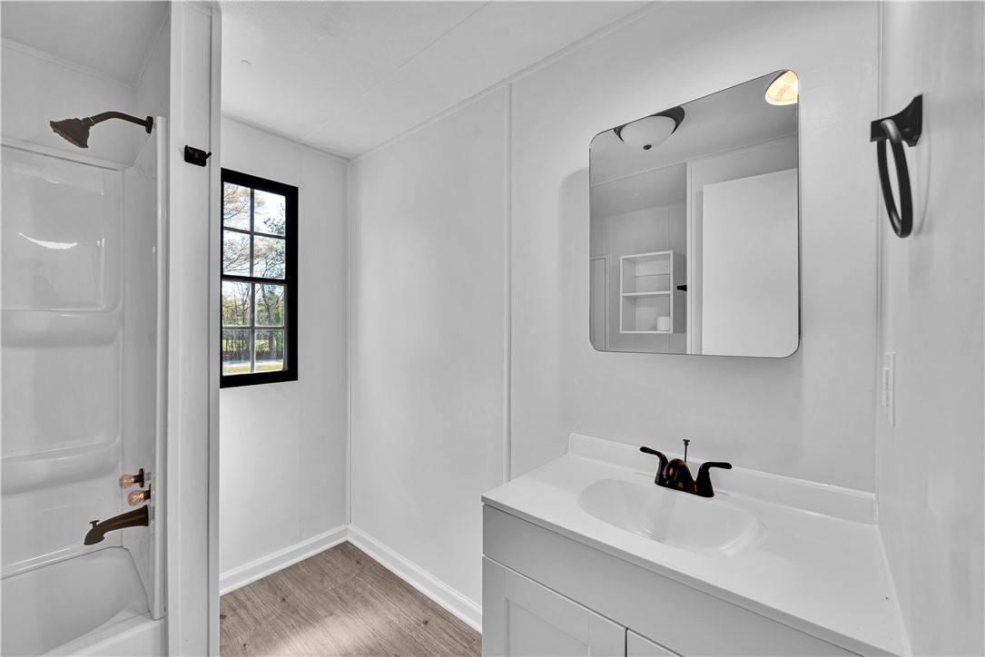 220 Bill Kay Road Belton, SC 29627 - Photo 10 of 30 This bright bathroom features a vanity, mirror, and a shower-tub combination.