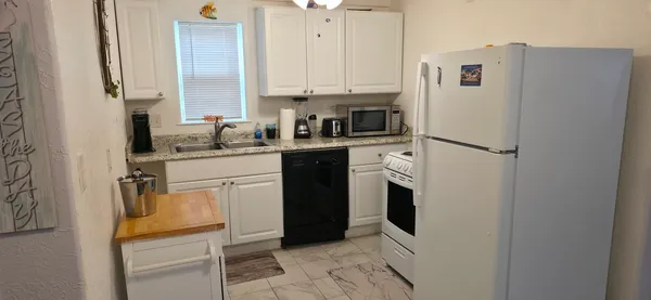 a kitchen with a refrigerator sink stove and cabinets