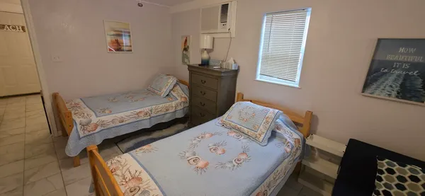 a bedroom with a bed a flat screen tv and a window