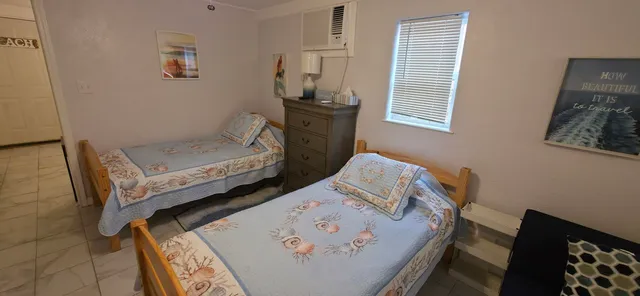 a bedroom with a bed a flat screen tv and a window