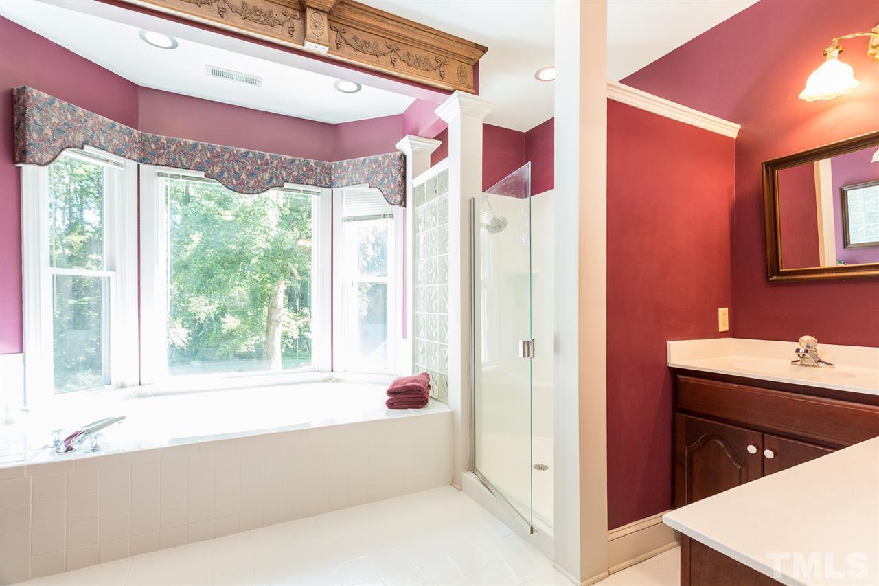 8329 Glory Road Zebulon, NC 27597 - Photo 20 of 30 This Master Bath boasts cabinet space. There are his/her vanities - one of which also has a sitting make-up desk. This walk-in shower has two shower heads! This bathroom tiles has been recently reglazed a neutral white color.
