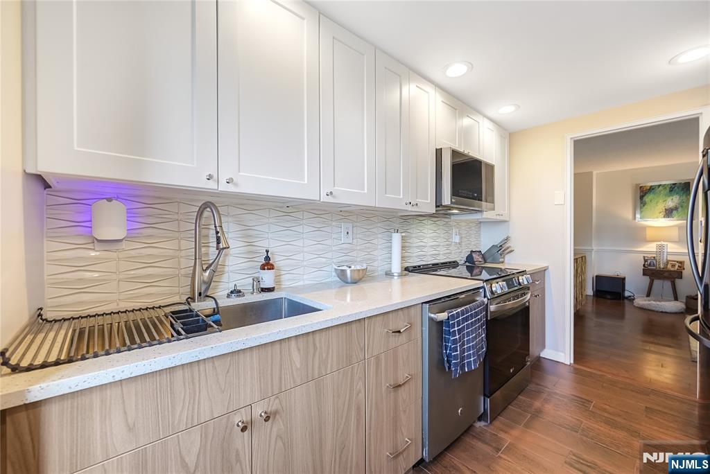 307 Prospect Avenue, Unit 9A Hackensack, NJ 07601 - Photo 9 of 29 a kitchen with stainless steel appliances granite countertop a stove a sink and white cabinets