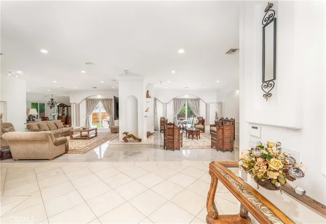 a living room with fireplace furniture and a view of kitchen
