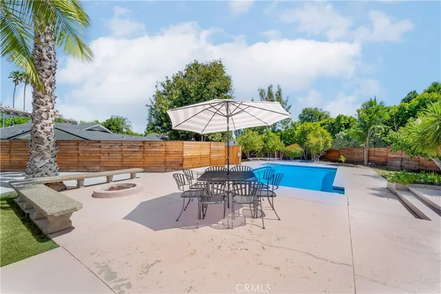 a view of a patio with table and chairs potted plants and palm tree