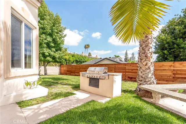 a view of white house with a yard and potted plants