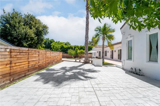 a view of swimming pool with lawn chairs and plants