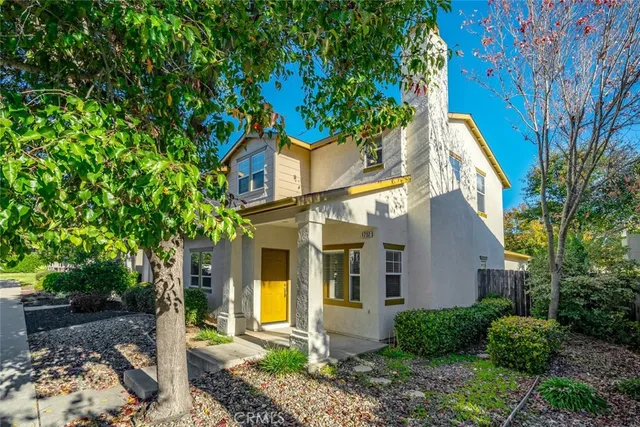 a view of a white house with a tree and a yard