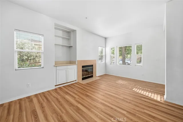 a view of empty room with a fireplace and wooden floor
