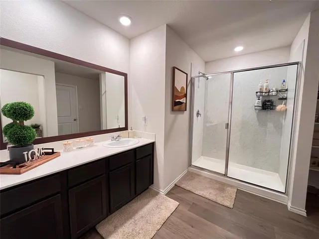 a bathroom with a glass shower door and a sink