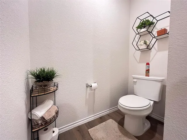 a view of a hallway with wooden floor and closet